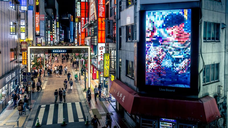 Crowded Shinjuku street in Tokyo at night, where travellers rely on an eSIM or roaming for mobile data