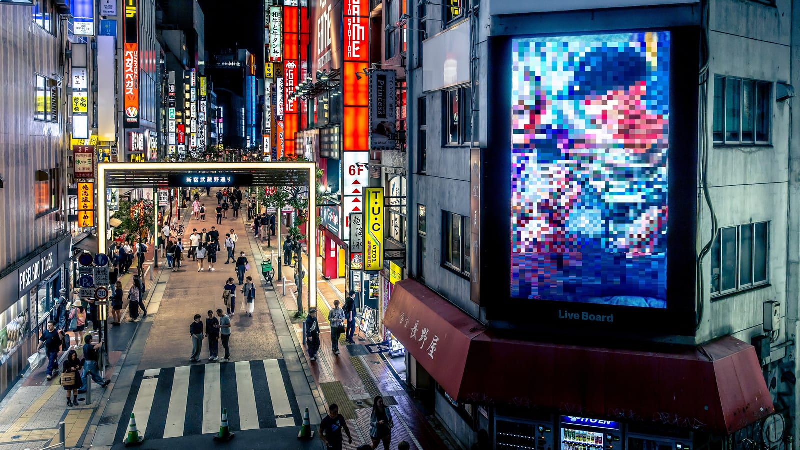 Crowded Shinjuku street in Tokyo at night, where travellers rely on an eSIM or roaming for mobile data