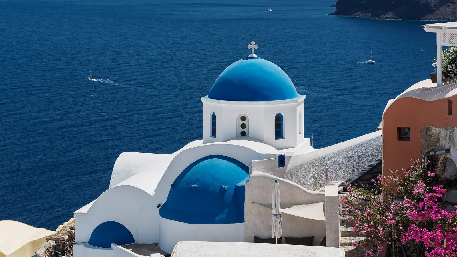 Blue-domed church and whitewashed buildings above the Aegean at Oia on Santorini, Greece